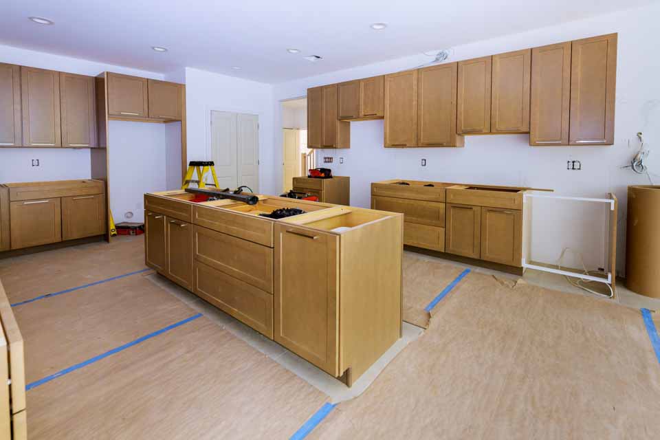 a kitchen renovation in the works displayed with unfinished cabinets